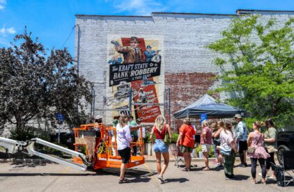 Group of people admiring a mural being painted