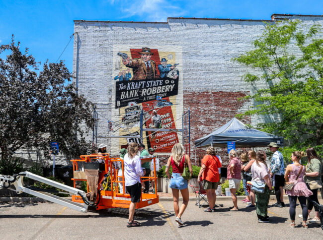 Group of people admiring a mural being painted