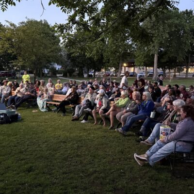 Group of people seated at a park waiting for event