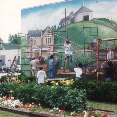 Old image of people painting on scaffolding