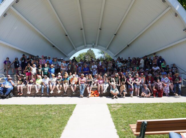 Large group of volunteers and artists in an outdoor amphitheater