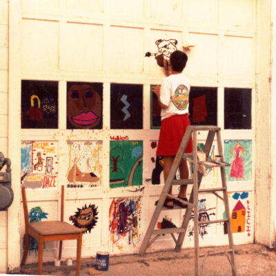 Old image of boy painting on a garage door