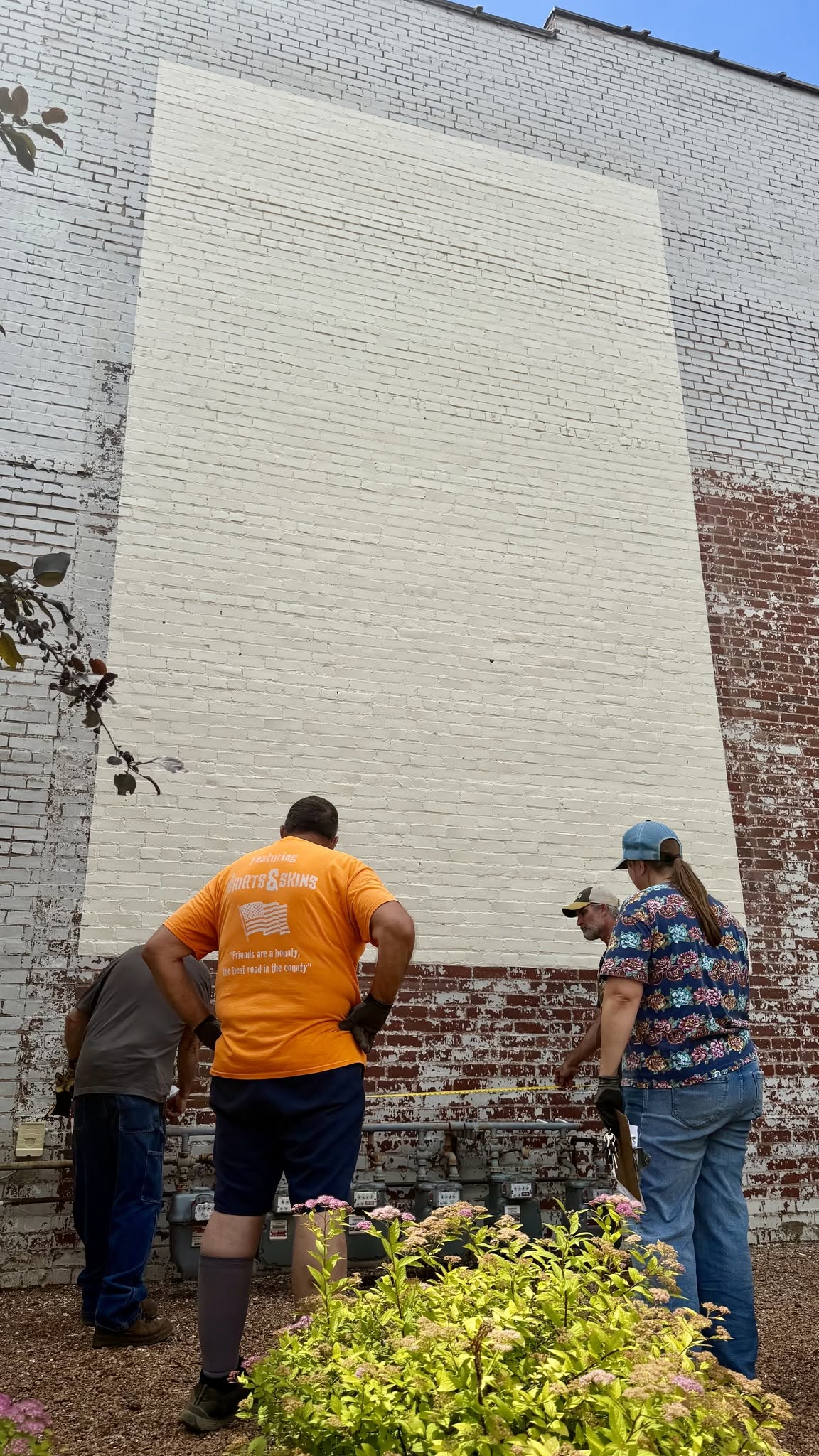 People measuring an area that will be painted