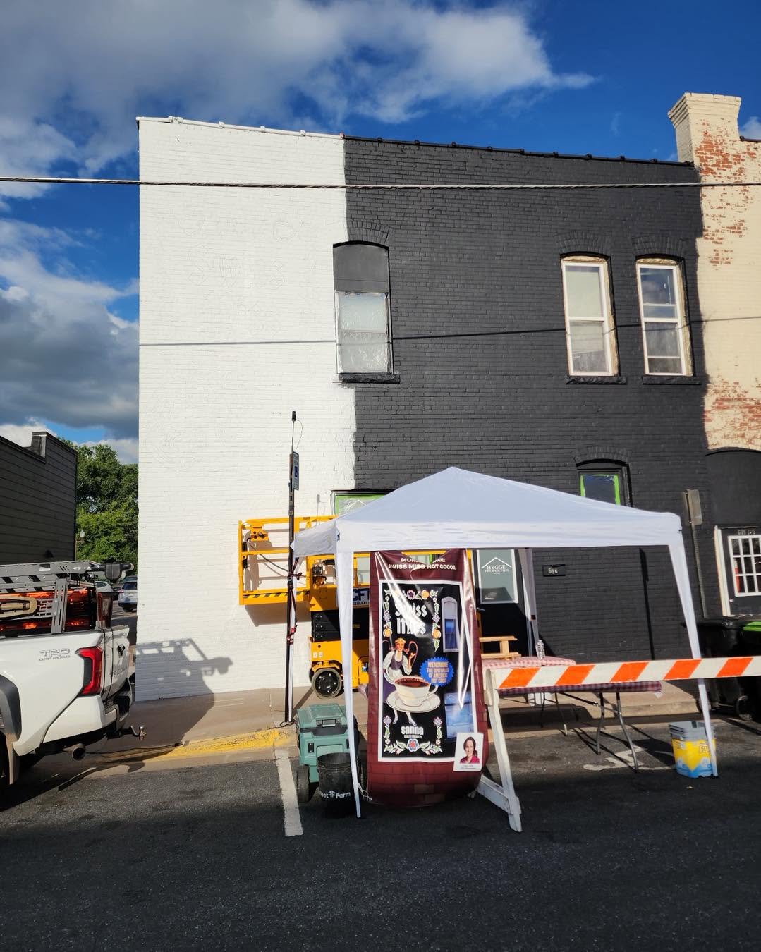 Popup tent on the street in front of a building that will be painted