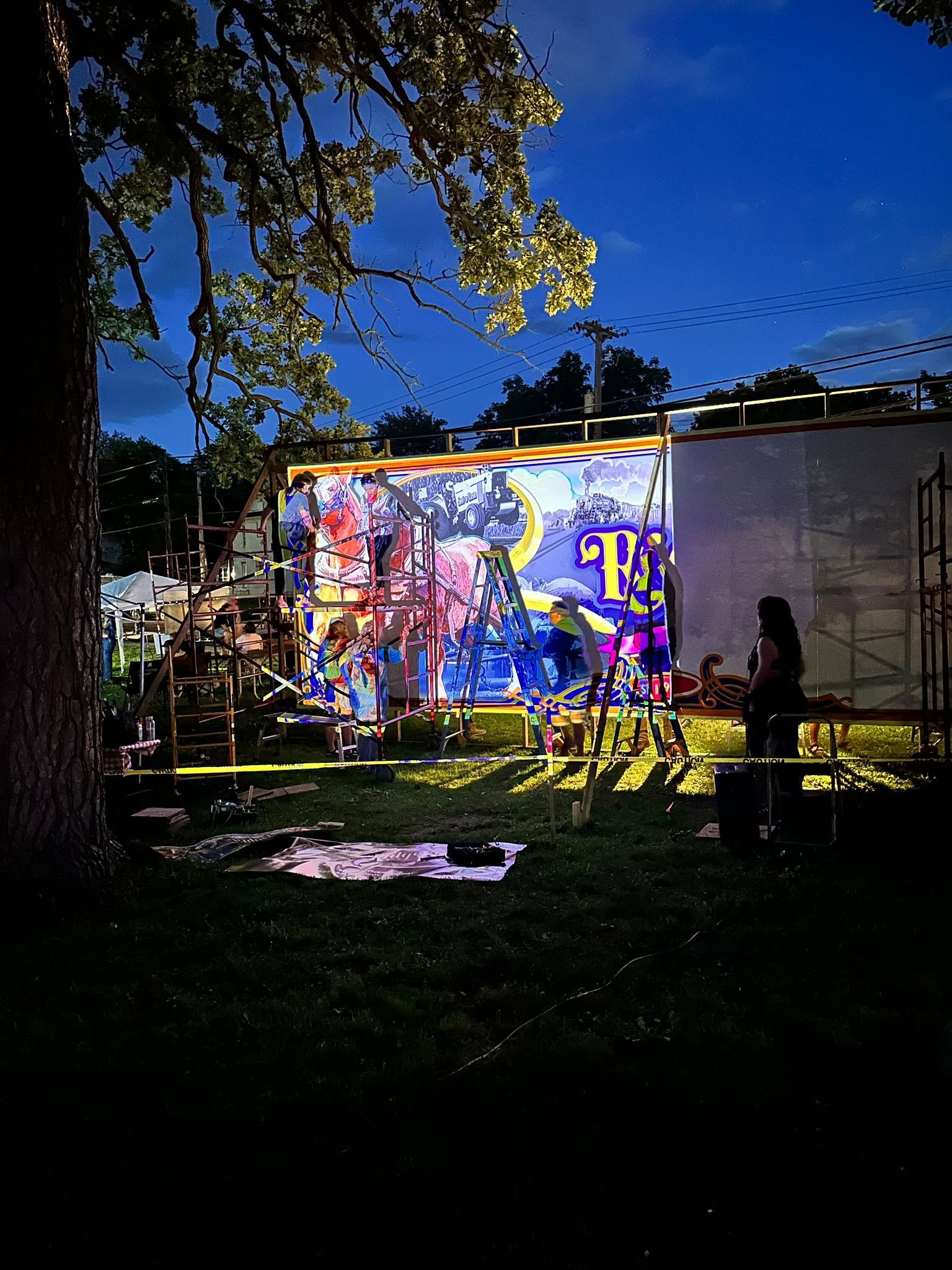 Artists painting at night while image is projected