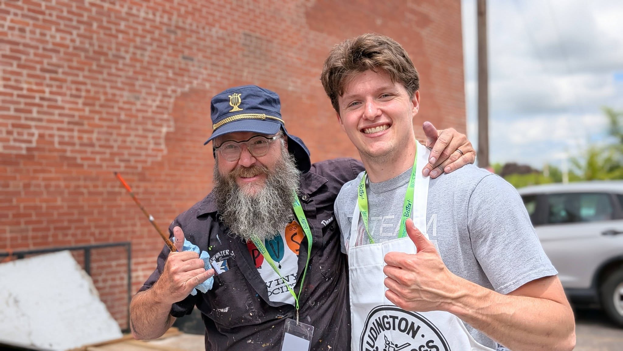 Two artist men smiling and giving thumbs up