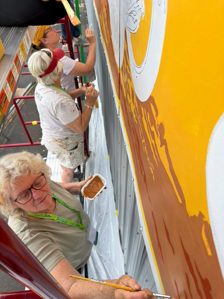 View from above of ladies holding paint and painting