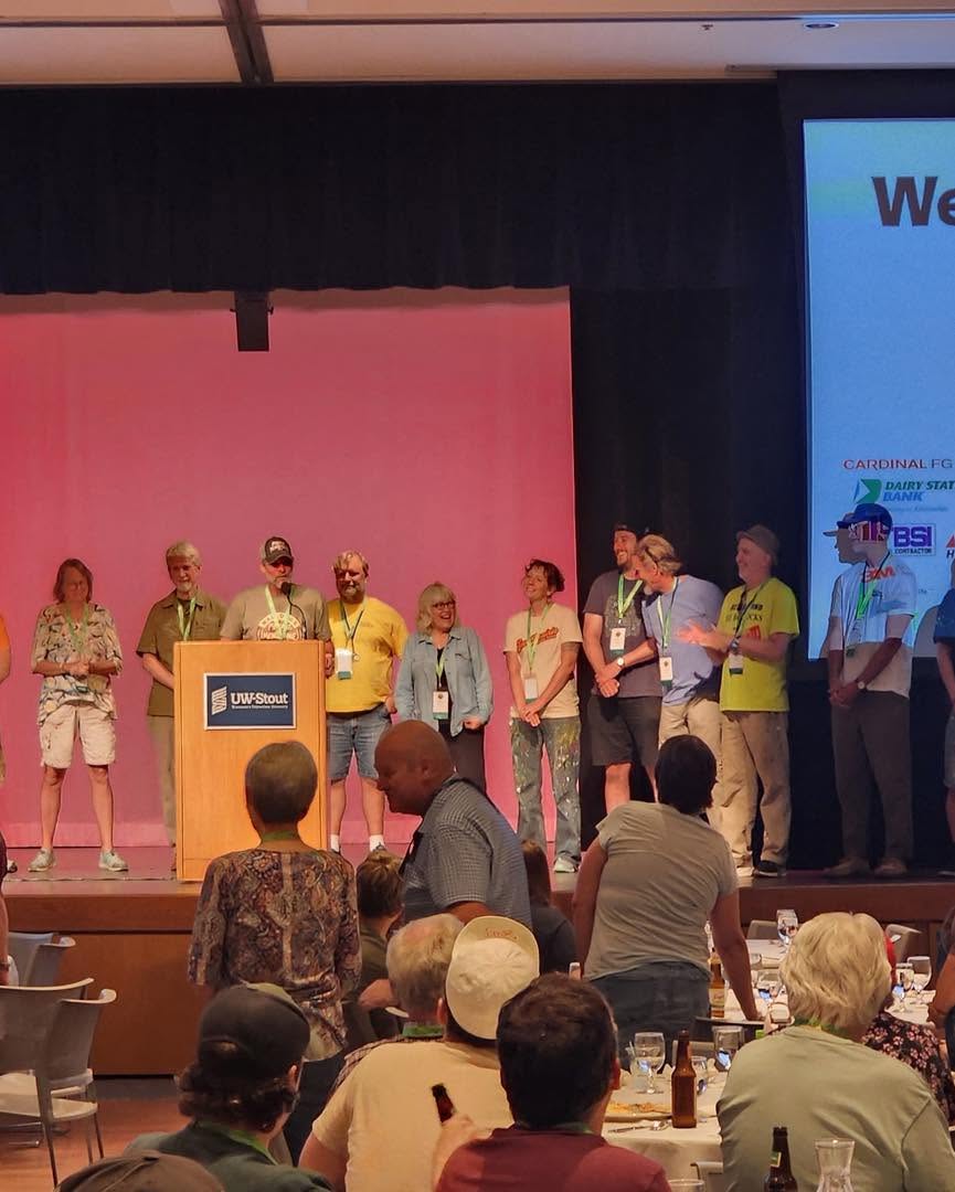Group of people on stage with people seated at tables below