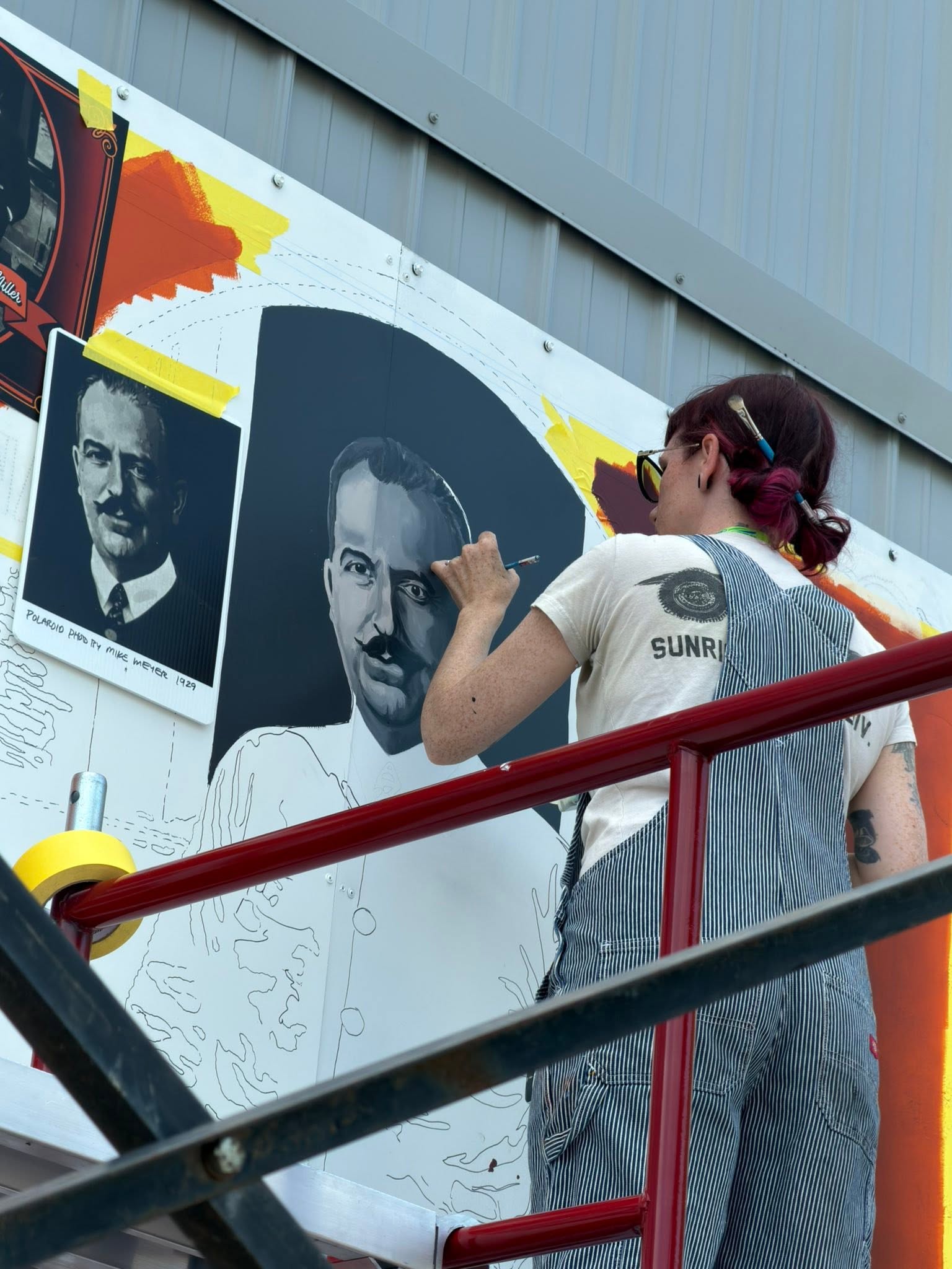 Artist painting a portrait in a mural