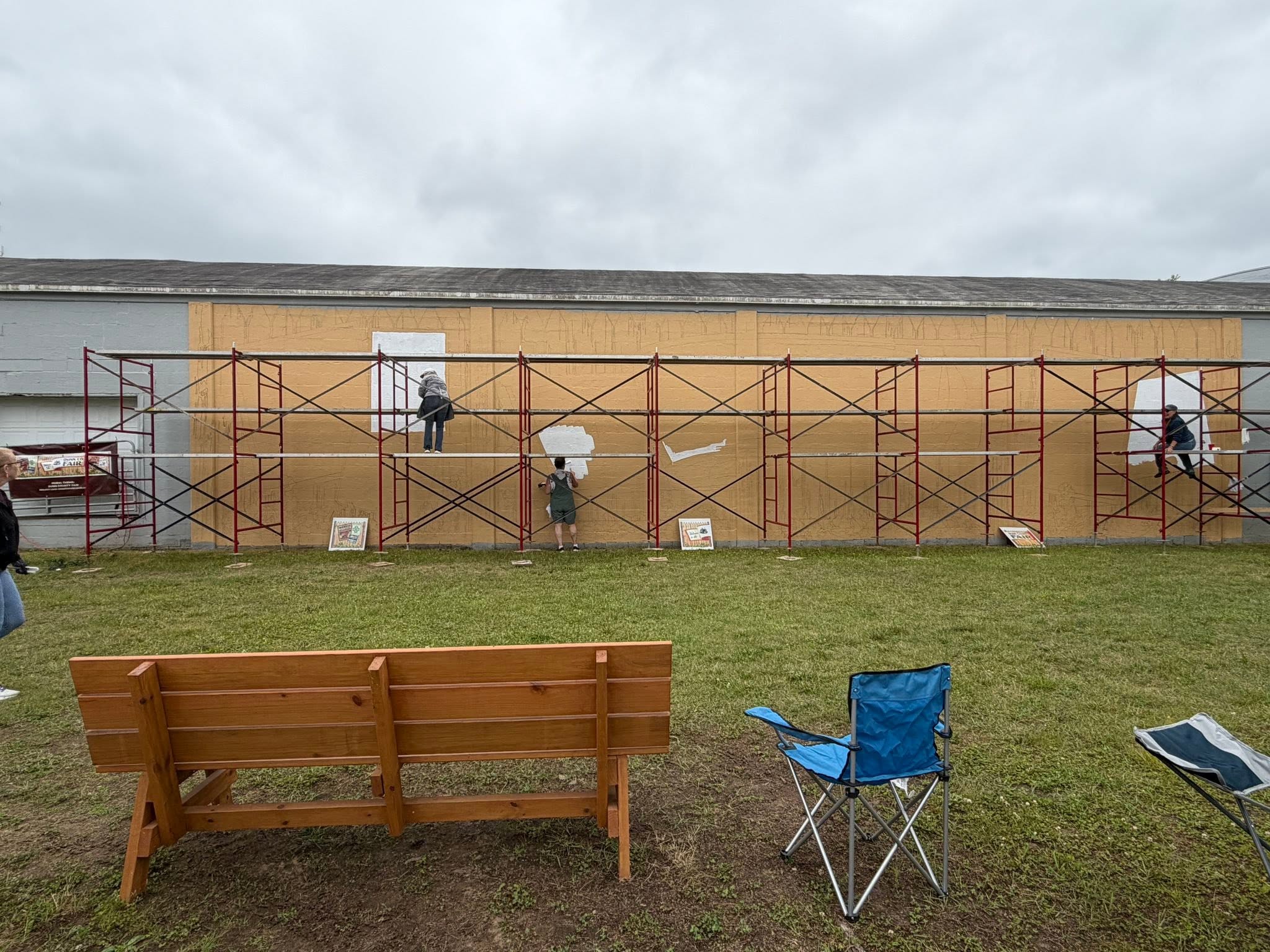 Scaffolding all across a long wall that is beginning to get painted
