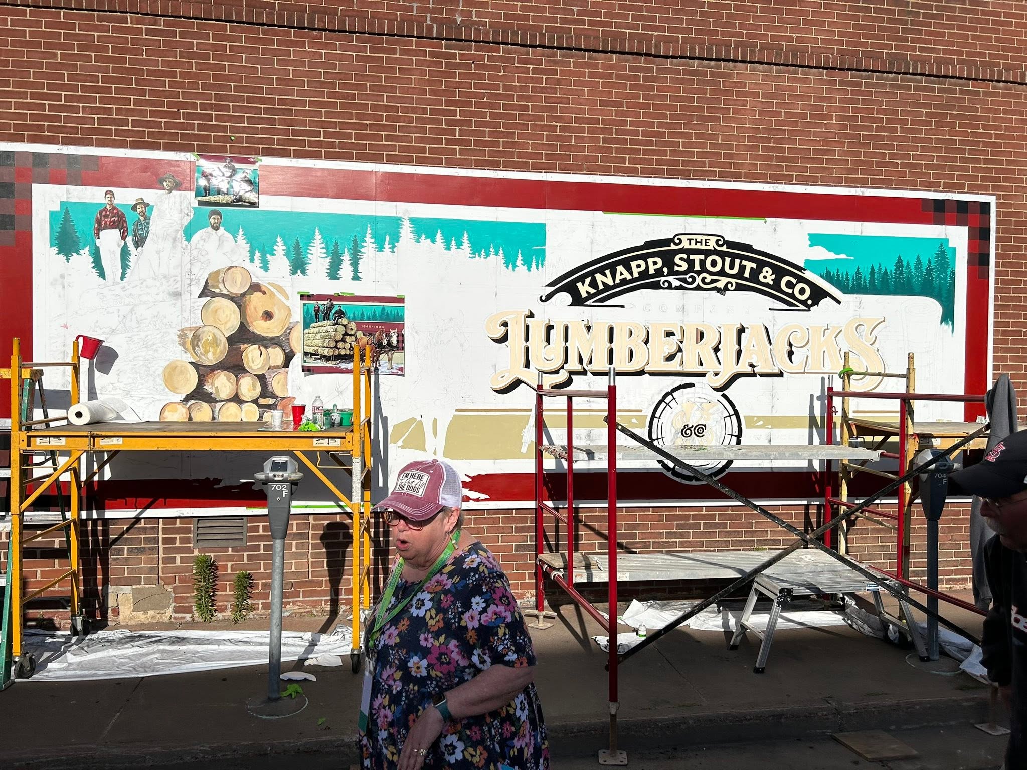 Person walking in front of unfinished mural