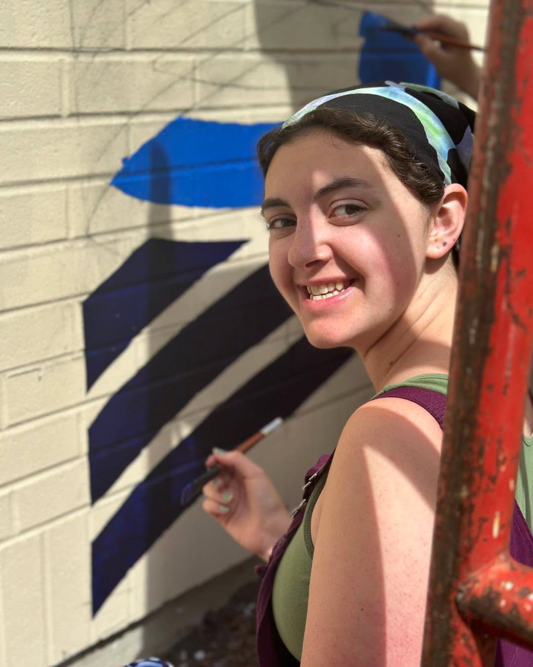 Girl with a paint brush smiling