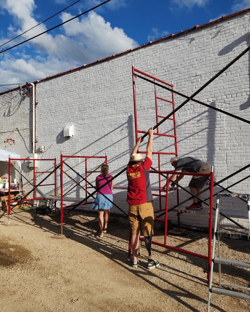 Volunteers assembling scaffolding