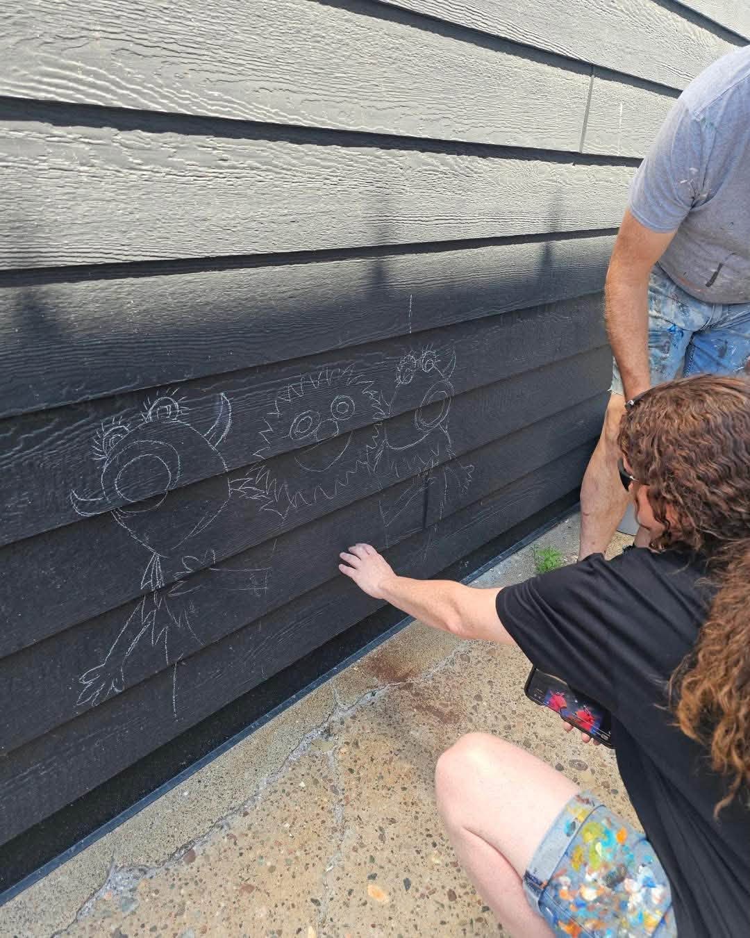 Person Pointing a wall where small monsters will be painted