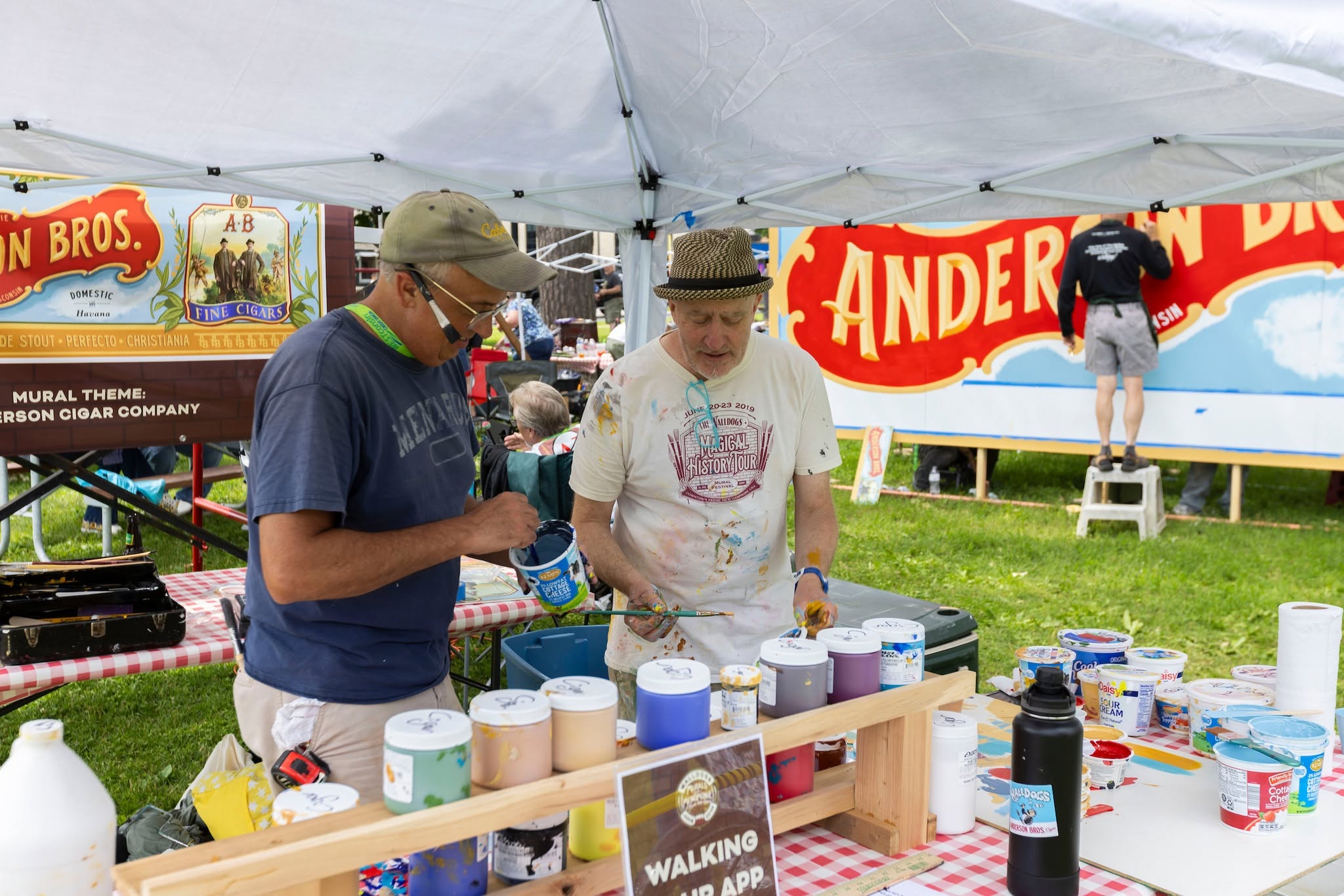 Volunteers and professional painters come together to paint around 14 murals for various businesses across Menomonie and nearby cities across four days. This includes a commisioned mural on the UW-Stout Polytechnic Administration Building.