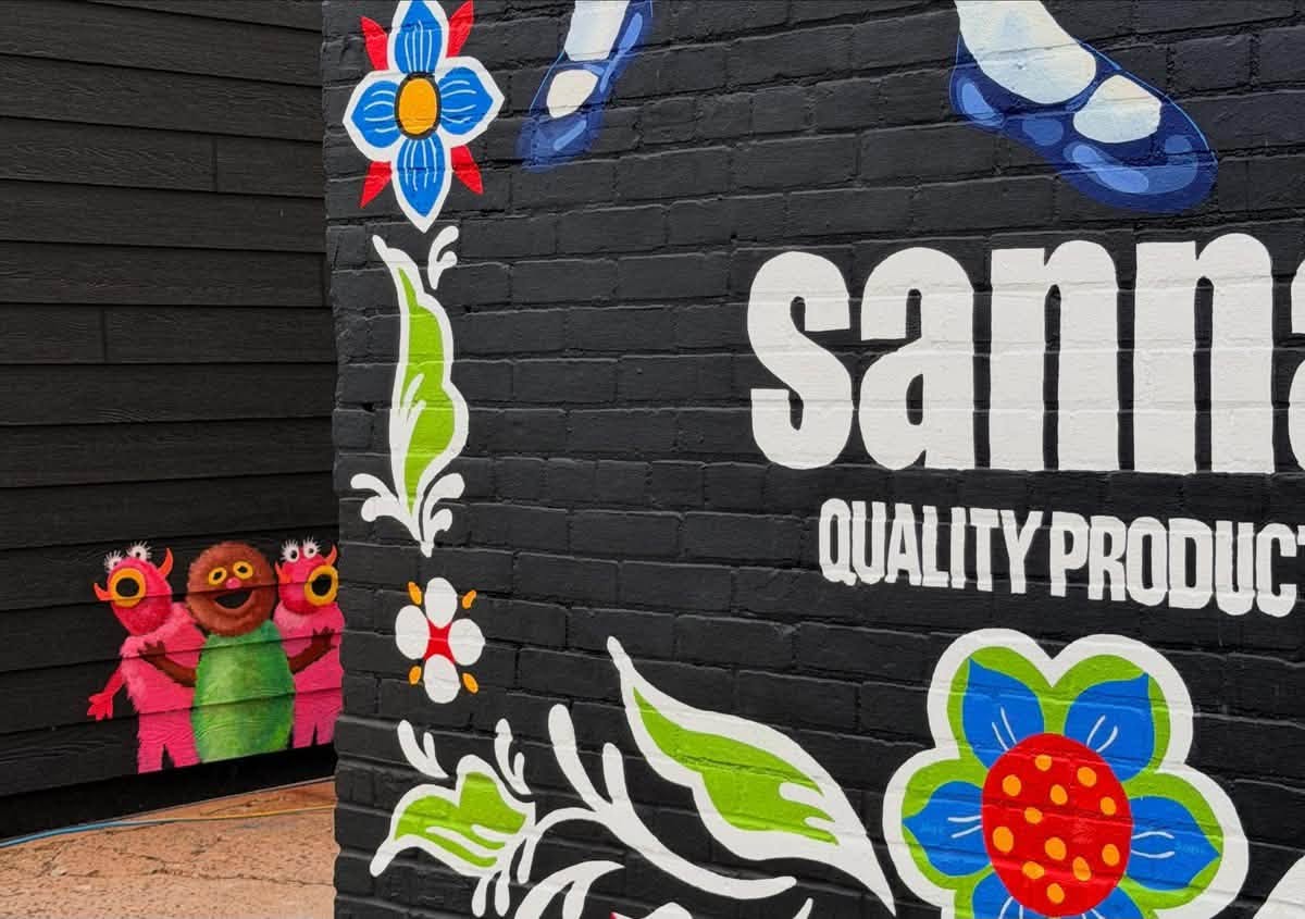 Black brick wall with vibrant colors painted and little monsters