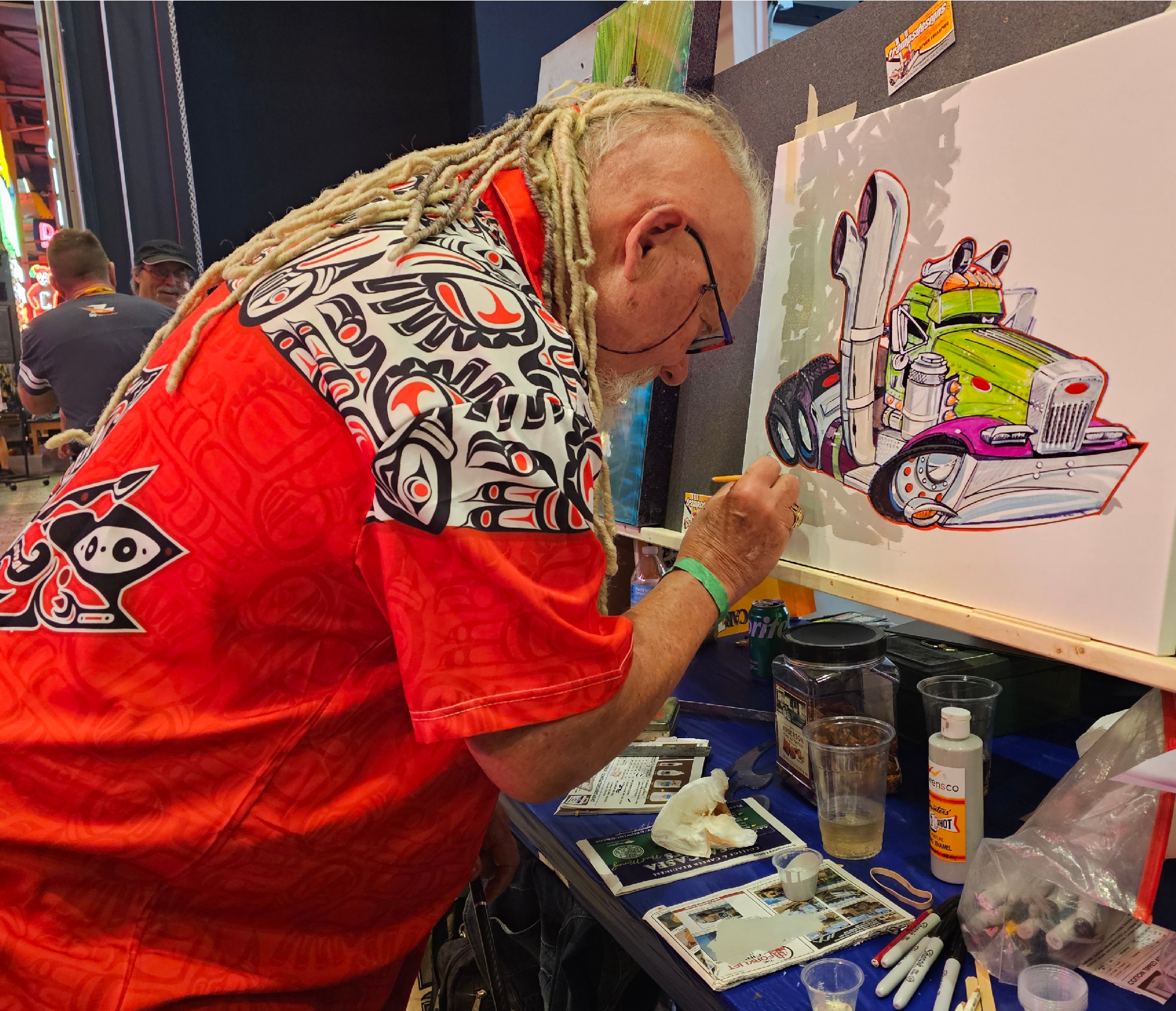 Man painting a cartoon semi truck on a canvas